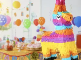 Fiesta infantil colorida con decoración de globos, mesa de dulces y piñata en forma de burro, ideal para celebraciones alegres y llenas de diversión.
