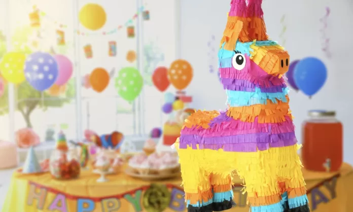 fiestas-tematicas-infantiles Fiesta infantil colorida con decoración de globos, mesa de dulces y piñata en forma de burro, ideal para celebraciones alegres y llenas de diversión.