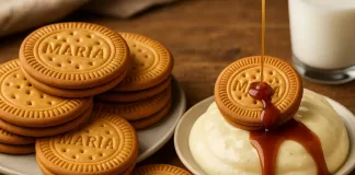 El legado de la galleta María: el sabor de un clásico que sigue vigente Taza de café latte con arte de leche acompañada de galletas María sobre mantel iluminado por la mañana.