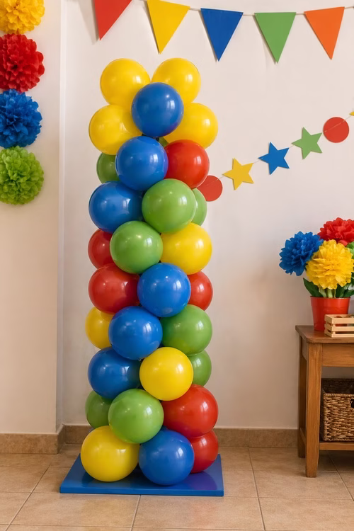 Columna de globos rojos, azules, amarillos y verdes junto a guirnaldas de papel