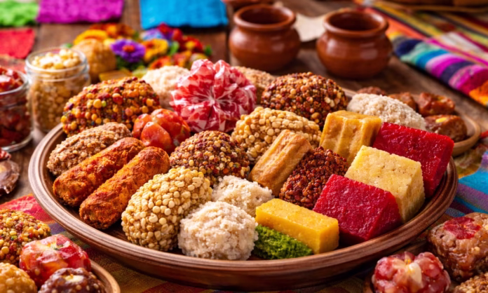 Bandeja con dulces típicos mexicanos variados, como cocadas, alegrías, palanquetas, jamoncillo y ate, presentada en mesa colorida de estilo artesanal.