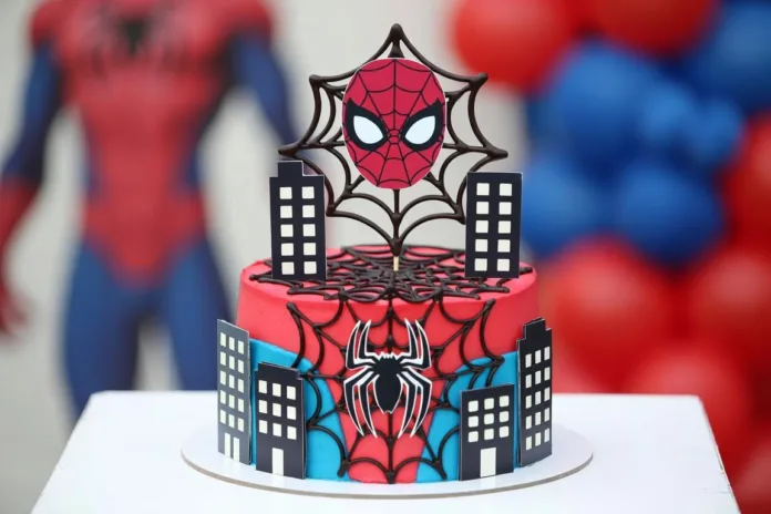tarta-spiderman Tarta Spiderman roja y azul con telarañas, edificios decorativos y topper de máscara para cumpleaños infantil